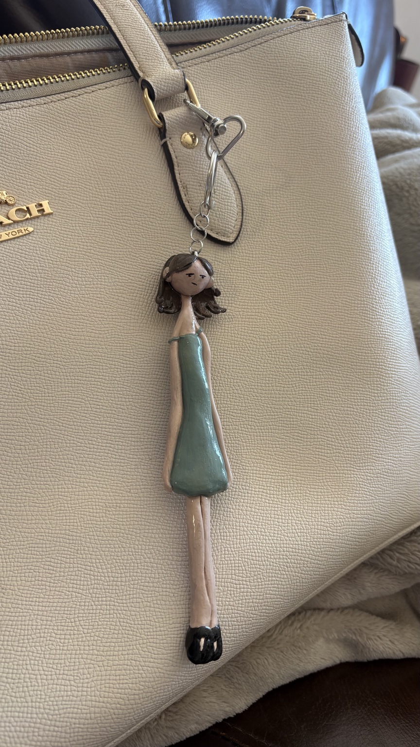 Mini charm hanging on purse