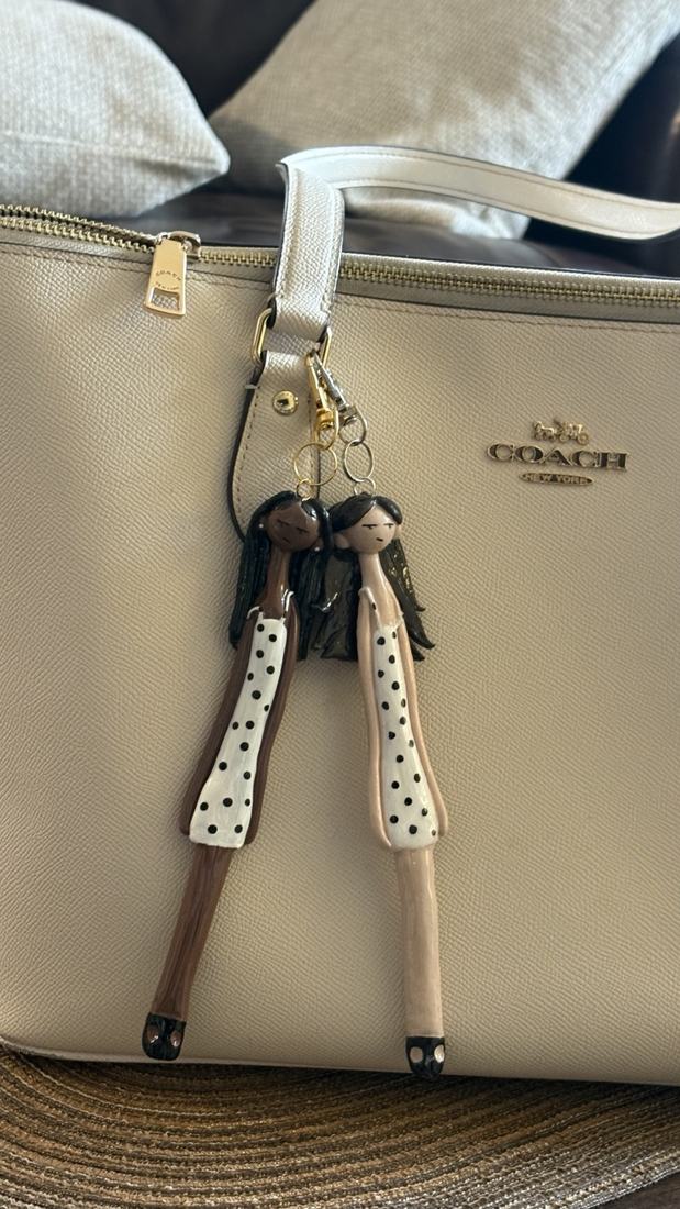 Two polka-dot Minis on a cream bag